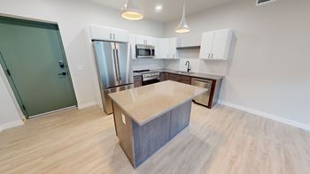 A kitchen with a table and a fridge.